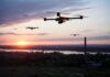 Drones flying over a river landscape at sunset