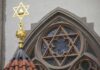Star of David atop synagogue roof with stained glass window