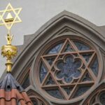 Star of David atop synagogue roof with stained glass window