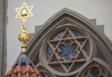 Star of David atop synagogue roof with stained glass window