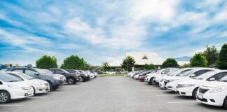 Parking lot lined with cars under a blue sky