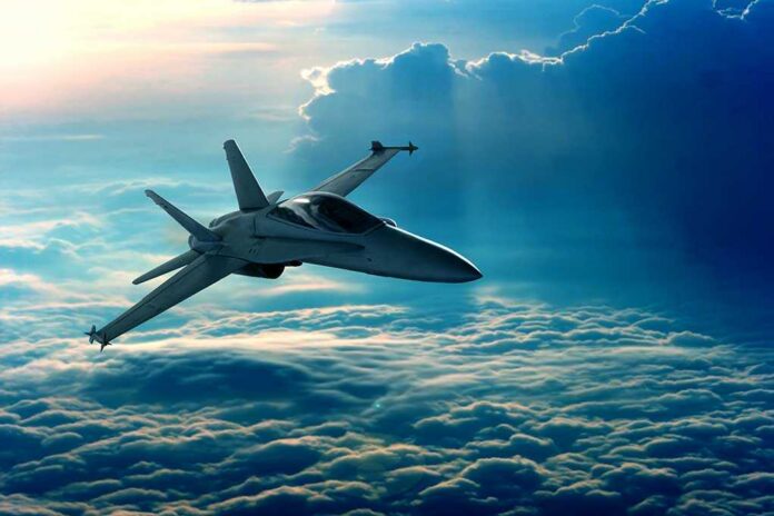 A fighter jet flying above the clouds during sunset