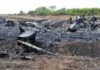 Airplane crash debris scattered across a burned field