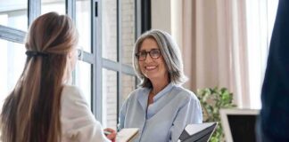 Smiling woman with gray hair talking in a modern office