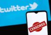 Former Co-Stars Clash Over Show’s Cancellation smartphone with censored stamp in front of blue social media logo