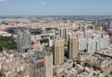 Aerial view of a sprawling urban city with high-rise buildings and green spaces