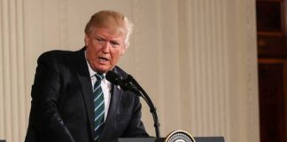Donald Trump speaking at a podium with presidential seal