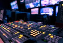 broadcast control room mixing console with illuminated buttons