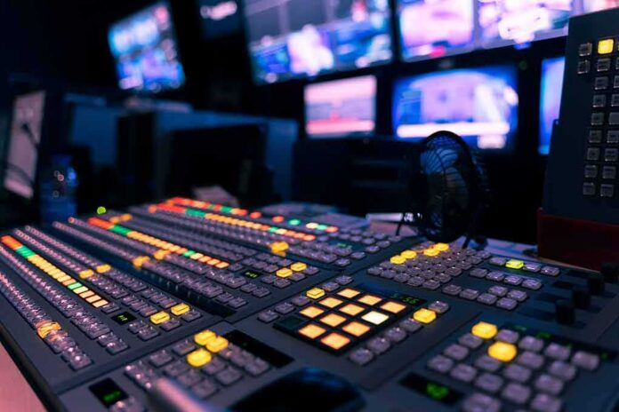 shutterstock_1791688289 broadcast control room mixing console with illuminated buttons