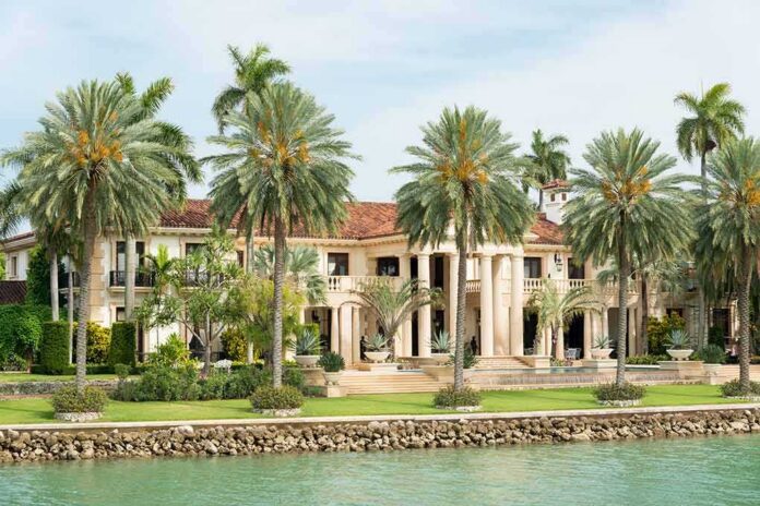 shutterstock_199184924 Waterfront mansion with palm trees and grand columns