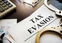 Handcuffs and calculator on tax evasion document